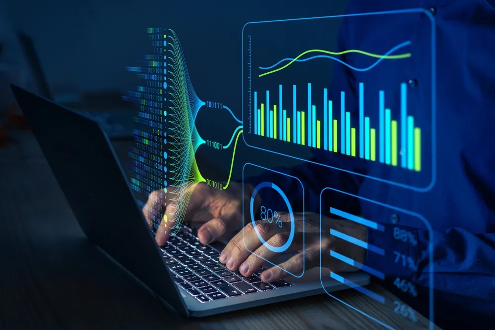 A person using a laptop in a dimly lit setting, featuring a glowing 3D digital overlay of complex bar charts, line graphs, binary data streams, and percentage indicators