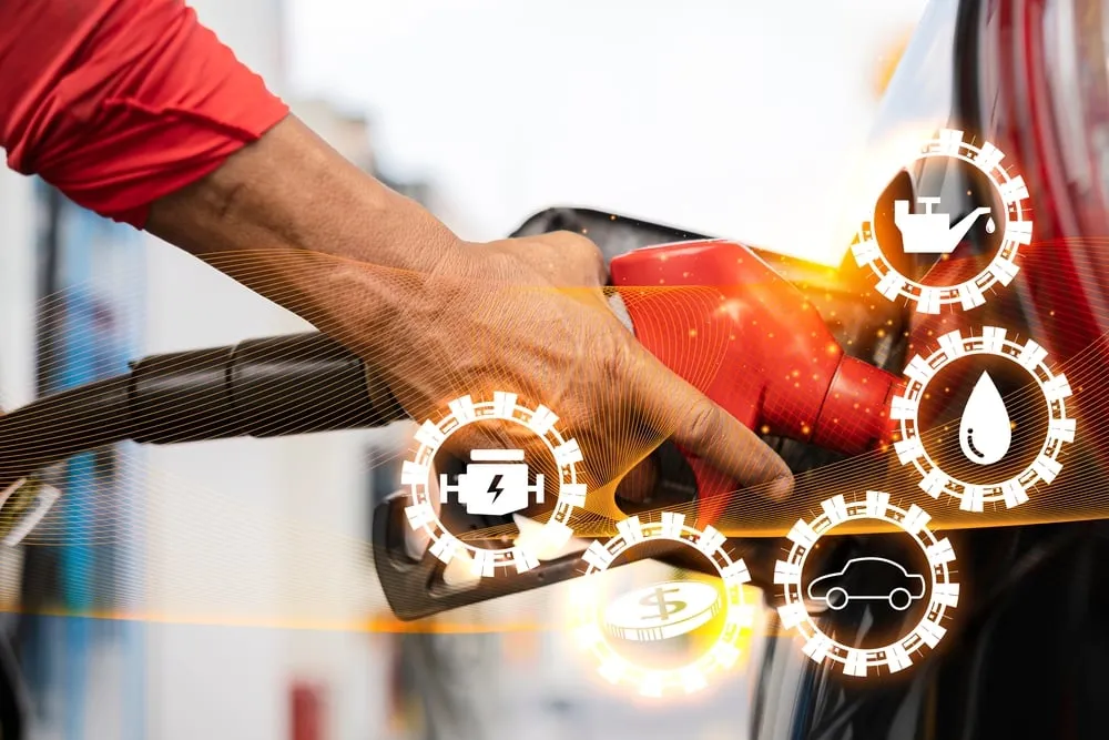 A hand holds a red fuel nozzle while refueling a car, featuring a digital overlay of icons for engine maintenance, oil, fuel costs, and vehicle diagnostics.