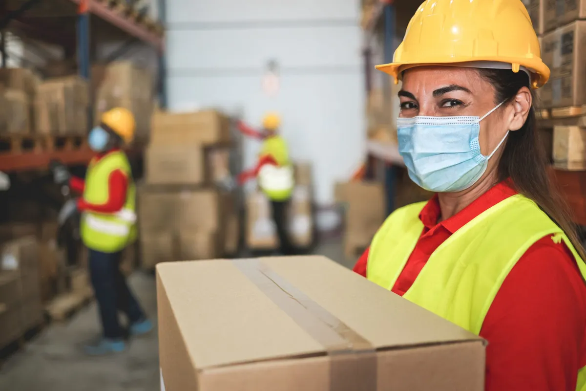 Woman,Worker,Inside,Warehouse,Loading,Delivery,Boxes,While,Wearing,Safety