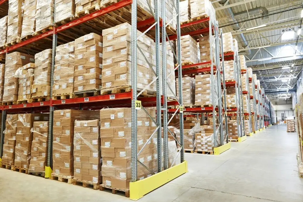 A wide view of a large, high-ceilinged warehouse filled with tall metal storage racks.