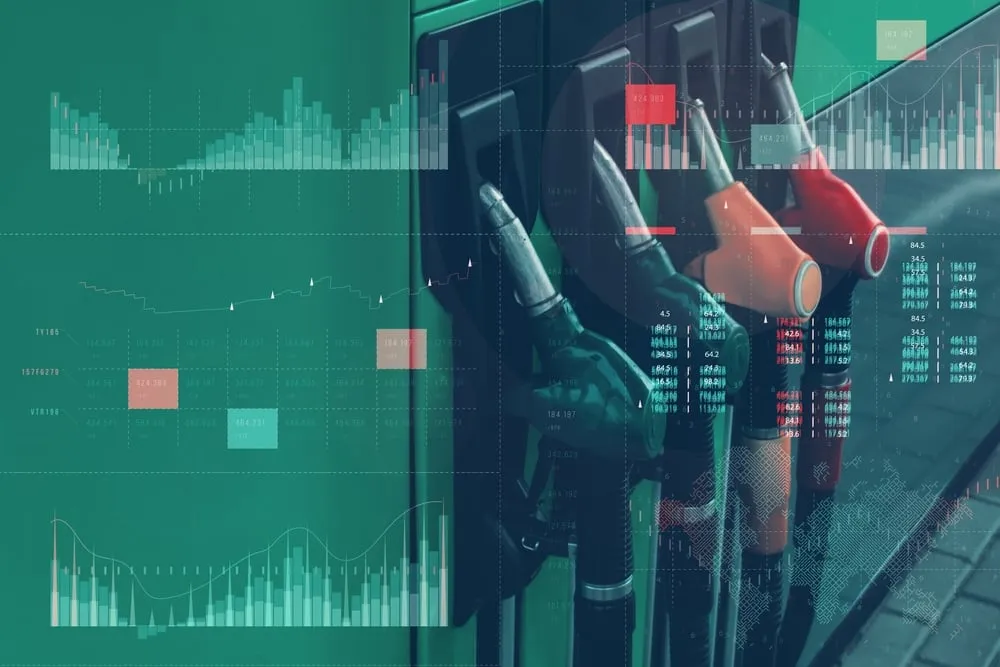 Fuel pump nozzles behind an overlay of charts and columns of figures